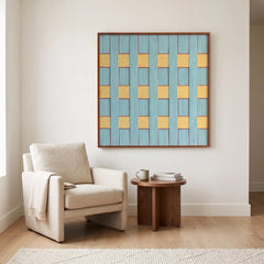 A large Afternoon Window hand-woven wool tapestry hung as a centerpiece above a cream armchair in a minimalist living room.