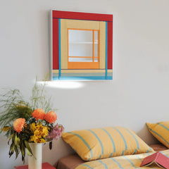 The geometric fiber art mirror styled in a bedroom setting above a bed with striped linens, creating a cohesive and cheerful aesthetic.