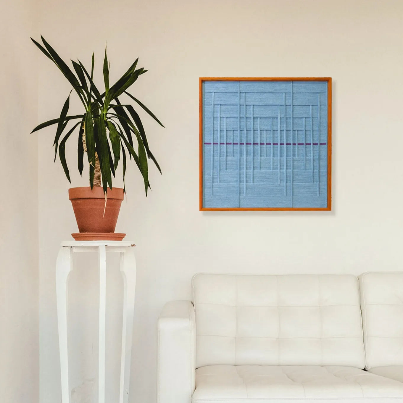 Blue Bridge Over the Pond wall art hung on a living room wall above a sofa, showcasing its square proportions and serene blue grid design
