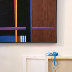 Close-up of Blue Tide Night Run showing the precise stitch detail where the red accent stripe meets the dark wood panel.
