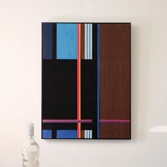 Blue Tide Night Run wall art installed above a desk next to a white lamp and small vase, highlighting its modern geometric stripe design and balanced color palette.
