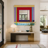Bohemian Reverie red, lavender, yellow, green, and turquoise yarn-framed mirror displayed above a console table in a bright entryway.