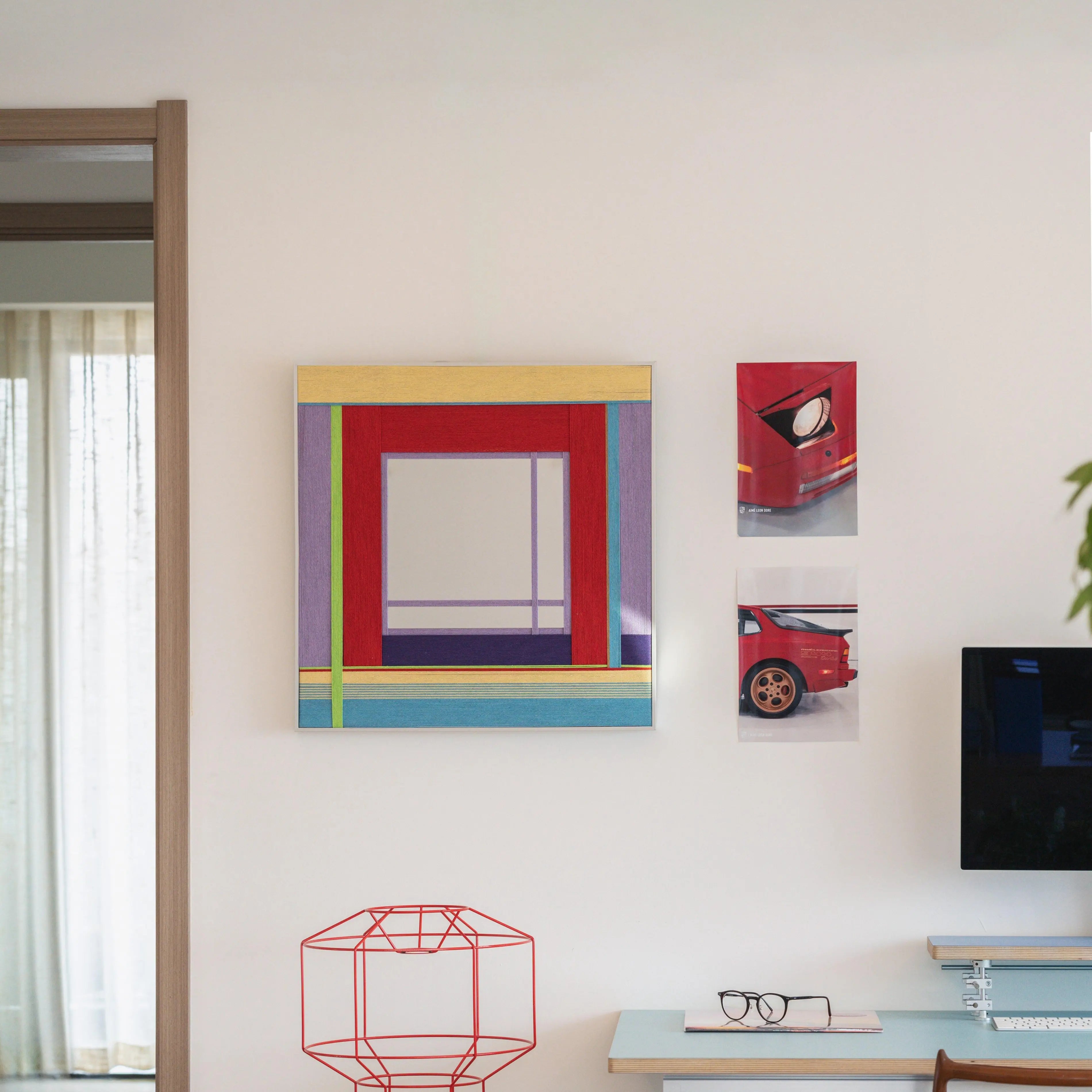 Bohemian Reverie yarn mirror art arranged on a shelf with decorative vases and books, highlighting its modern geometric layout.
