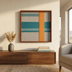 Vibrant teal and orange woven textile art hanging above a low wooden media console in a contemporary, warm-toned lounge area.