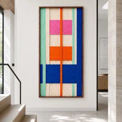Modern hallway interior showcasing the large vertical framed hand-woven wool tapestry featuring geometric blocks of color against a neutral wall.