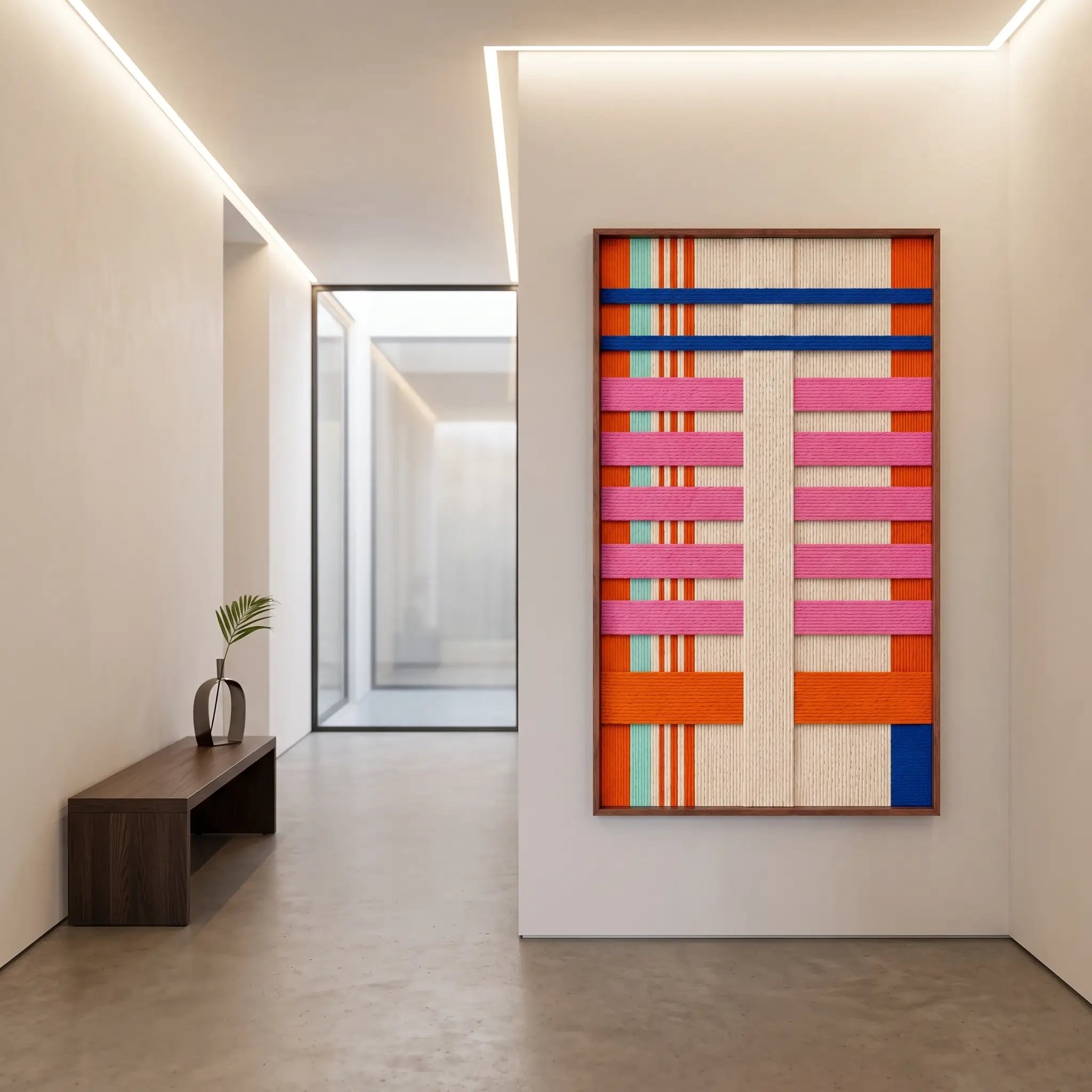 A large California Rhythm hand-woven wool tapestry displayed in a bright modern hallway above a wooden bench.