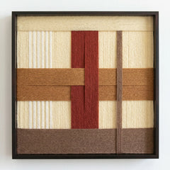 Professional studio shot of the Captured Radiance hand-woven wool wall art in a black frame against a clean white background.