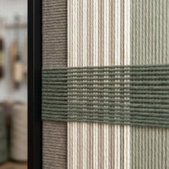 Detailed macro close-up of the Celadon Mist hand-woven textile art highlighting the textured sage green horizontal yarn crossing over cream and grey vertical stripes.