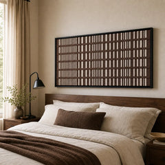 A beautiful framed hand-woven wool tapestry displayed gracefully above a styled bed with matching brown and cream accents in a cozy bedroom.
