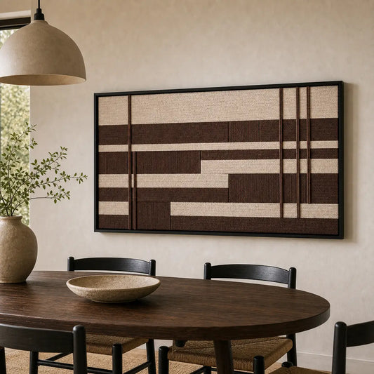 Earth-toned geometric hand-woven wool tapestry beautifully staged in a warm dining room, hanging over a dark round dining table and chairs.
