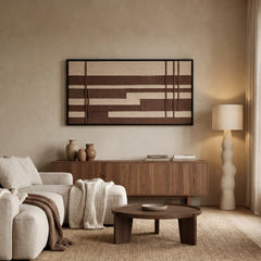 Framed Cocoa Grid hand-woven wall art displayed gracefully above a dark wood credenza in a serene, neutral-toned living room setting.