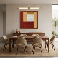 The Crimson Daybreak warm hand-woven wool tapestry provides a striking focal point over a wooden dining table and matching chairs in a contemporary dining room.
