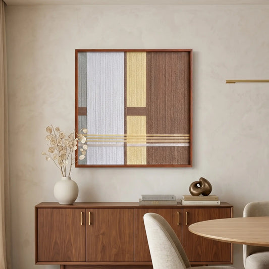 Textured wool wall decor in a wooden frame placed above a dining room credenza, featuring organic materials and a warm color palette.