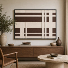 Framed Earthen Bands hand-woven wall art displayed above a light wood console table in a serene, earthy-toned living room setting.