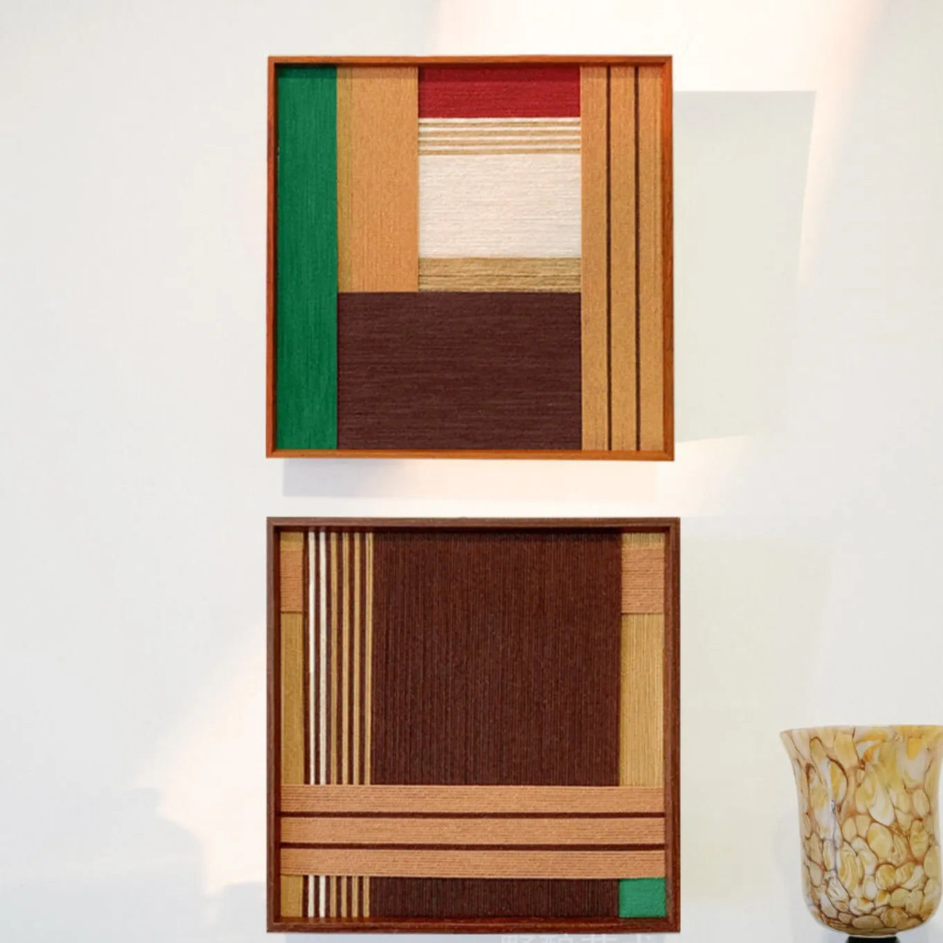 Earthy Fragrance yarn art paired with a complementary panel, featuring coordinated earth-tone stripe grids in matching wood frames
