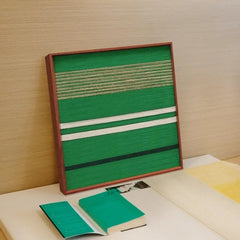 Endless Flow hand-woven wool yarn wall art flat lay view showing uniform stripe widths and precise geometric weave on a tabletop
