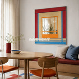 Fields of Blossoms colorful yarn-framed mirror displayed beside a round wood table in a bright modern dining nook.