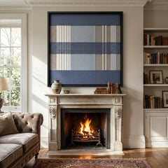 Large square Foggy Pier hand-woven wall art hanging elegantly above a classic fireplace mantel in a cozy, softly lit living room with a crackling fire.