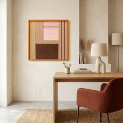 Framed textured fiber wall art hanging in a minimalist home office above a wooden desk with a terracotta swivel chair.