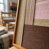 An angled close-up showing the rich, tactile soft cotton cord textures and the professional oak wood frame of the wall art.