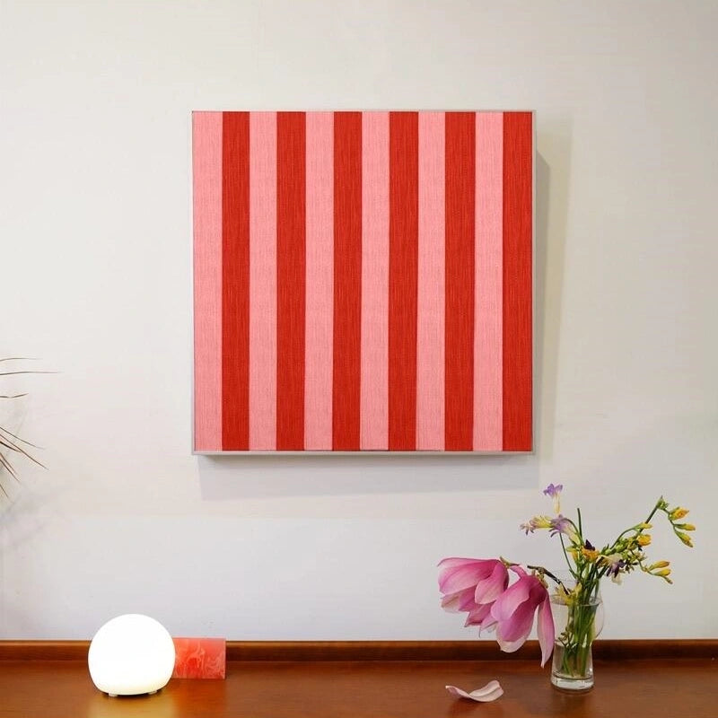 Front view of Hana & Alice yarn wall art on a clean white wall, highlighting its square format and striking red stripe design
