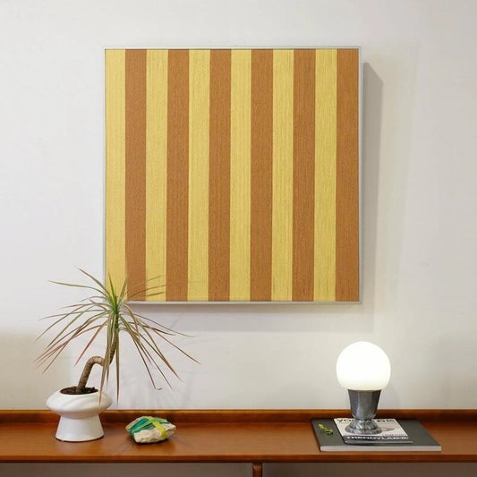 Hana & Alice yellow stripe variant front view on a white wall, featuring alternating warm yellow and cream yarn stripes for a sunny accent
