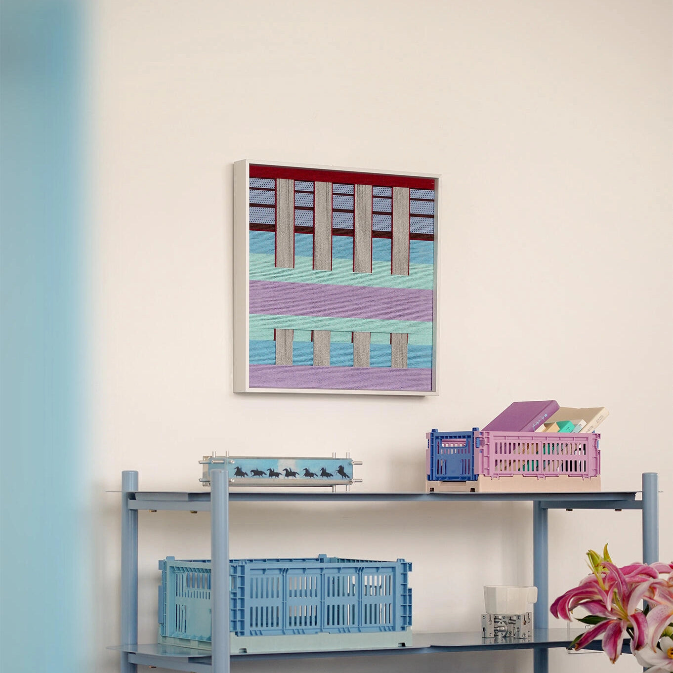 Hanosen Anji yarn wall art styled on a desk with lamp and decorative objects, highlighting its seamless pastel grid design
