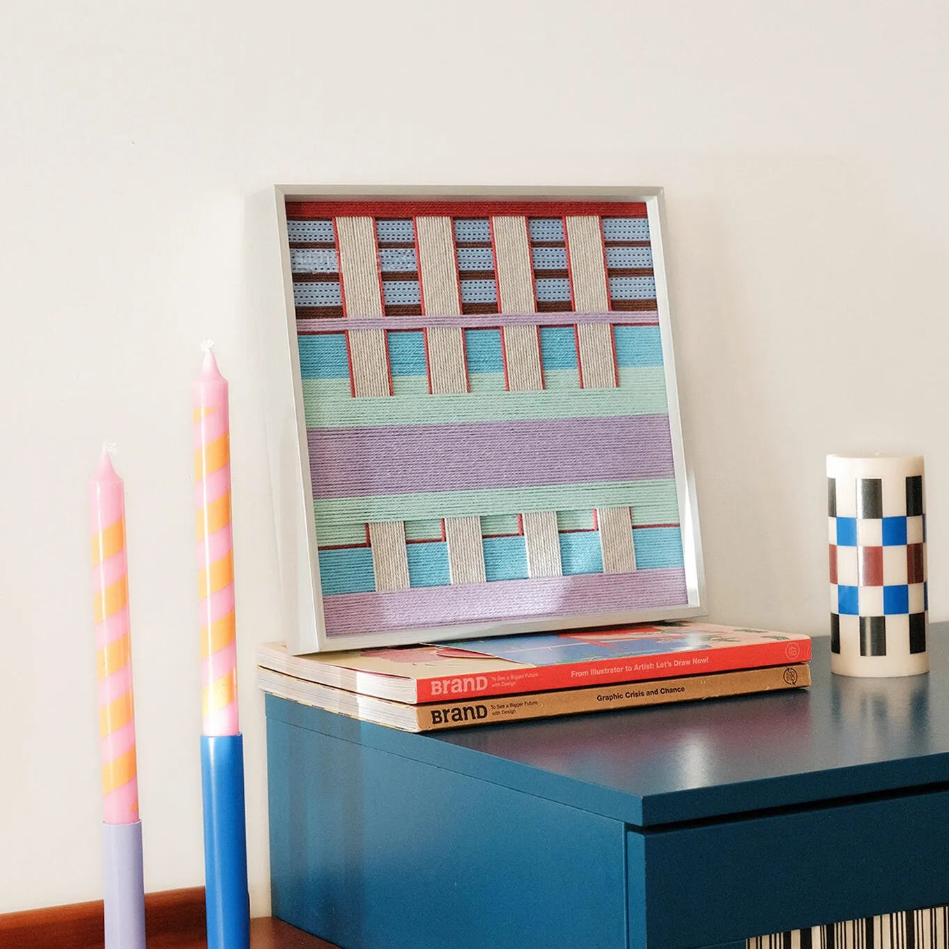 Hand-held view of Hanosen Anji yarn wall art showing its compact square format and smooth, looped wool texture
