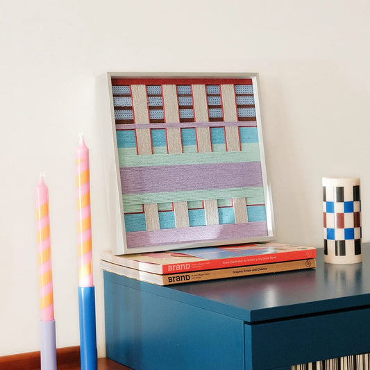 Hand-held view of Hanosen Anji yarn wall art showing its compact square format and smooth, looped wool texture
