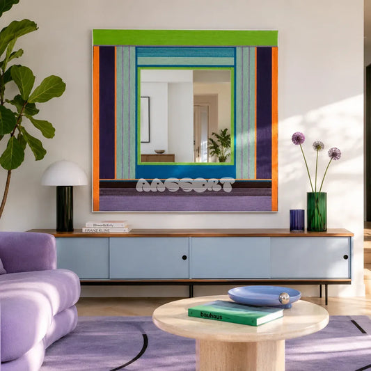Hidden Forest green, purple, blue, and orange yarn-framed mirror displayed above a blue sideboard in a colorful modern living room.