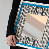 Close-up of Inception SQ016 showing black-and-white yarnwork, blue border and silver metal frame.