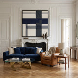 Large square Midnight Axis framed wall art hanging above a plush navy blue sofa in a bright, modern living room setting.