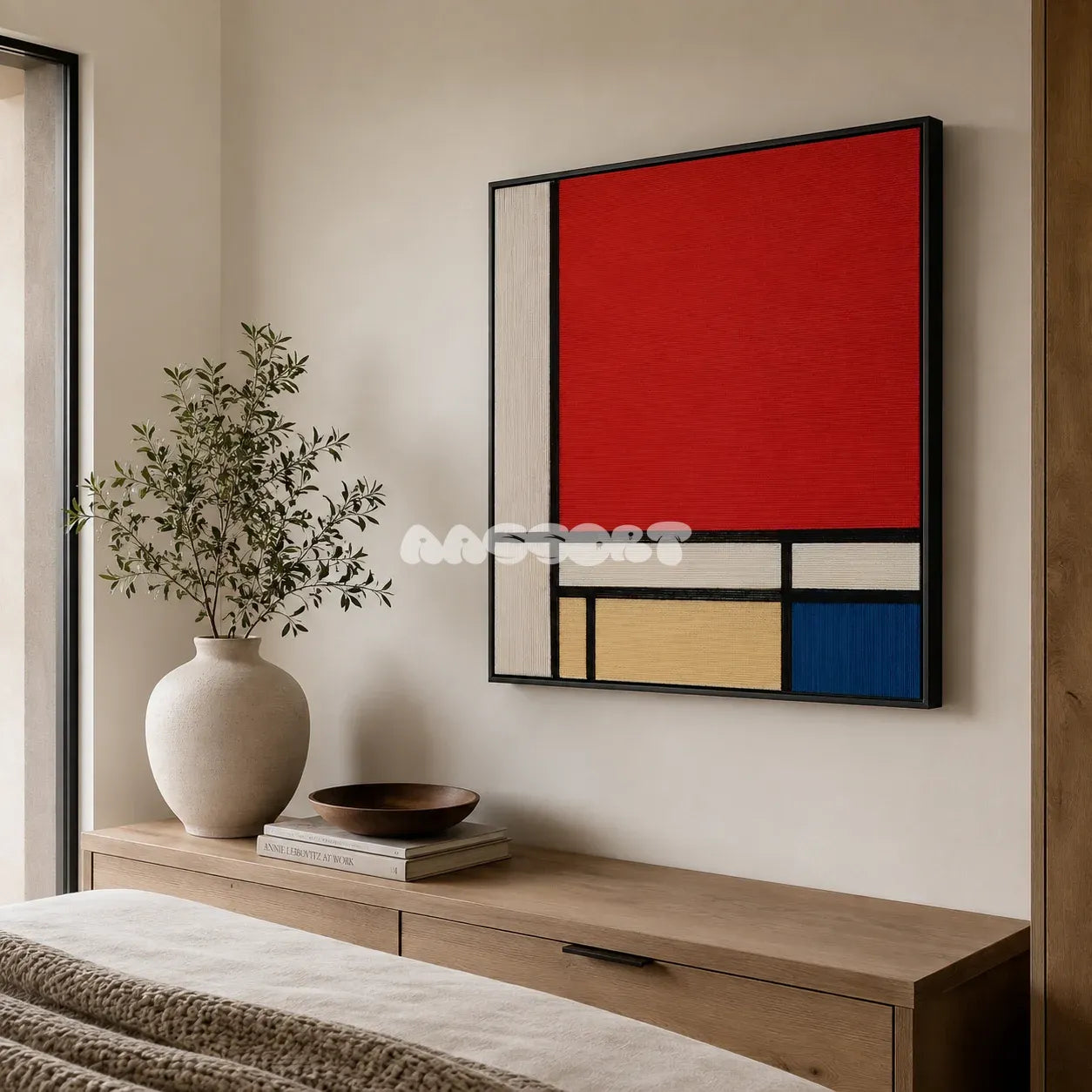 Mondrian red blue yellow and black textile wall art featured above a light wood dresser in a warm neutral bedroom.