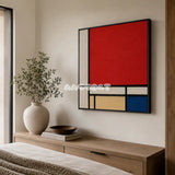 Mondrian red blue yellow and black textile wall art featured above a light wood dresser in a warm neutral bedroom.