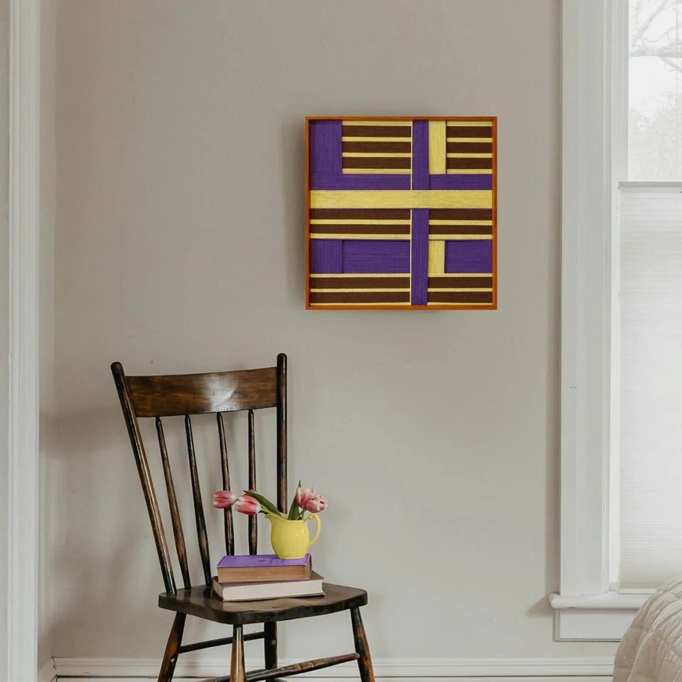 Mrs. Maisel wall art mounted in a doorway, demonstrating compact square design and modern color-block weave.
