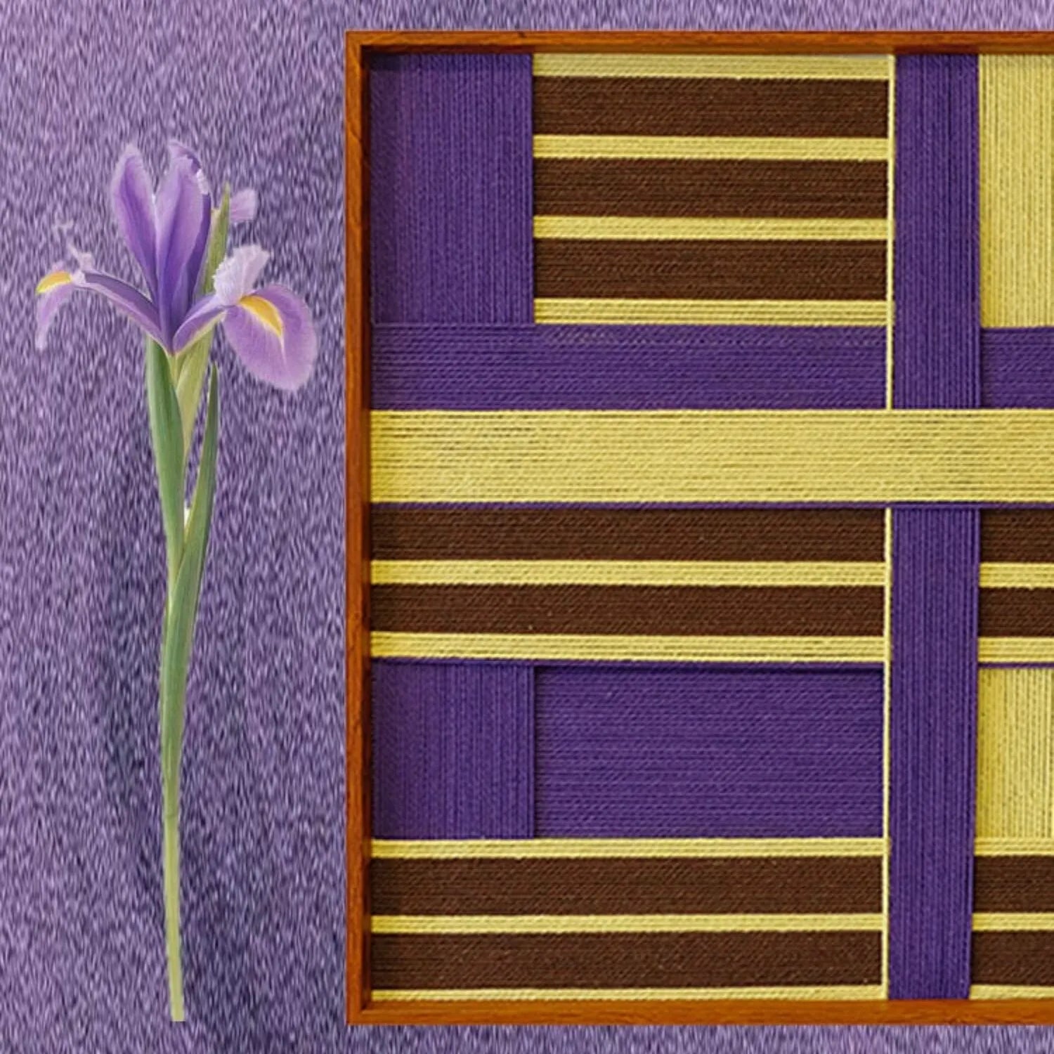 Close-up of Mrs. Maisel yarn wall art with a dried iris flower resting beside it, emphasizing the tactile wool texture and grid motif.
