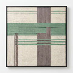 Frontal studio shot of the Muted Spring hand-woven wool wall art featuring sage green, grey, and cream geometric patterns in a black frame against a clean white background.