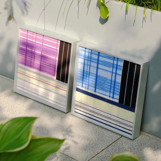 Night River Lantern yarn wall art diptych placed on a metal grate outdoors, showcasing its robust wool texture and vibrant stripe patterns side by side.
