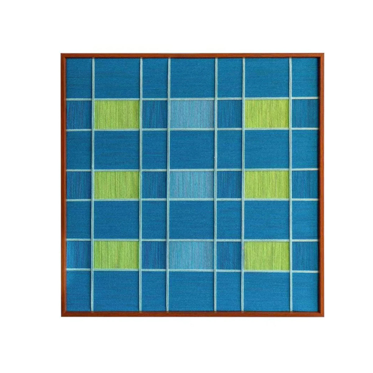 Studio front view of the hand-woven wool wall art featuring a geometric checkerboard pattern in shades of deep ocean blue and bright green.