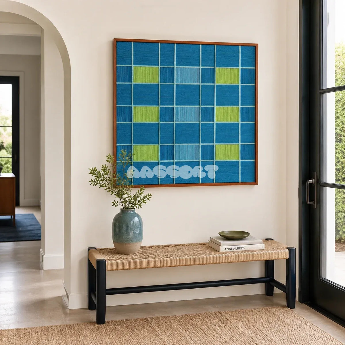 North Sea Poem ocean blue, sky blue, and lime green geometric yarn wall art displayed above a woven bench in a modern entryway.