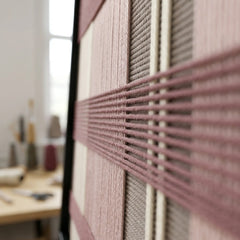 Extreme angled macro close-up of the Nostalgic Bloom hand-woven textile art highlighting the textured mauve horizontal yarn crossing over cream, pink, and grey vertical stripes.