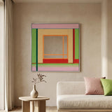 Large hand-woven wool wall art with green and pink geometric patterns displayed above a modern cream sofa and stone coffee table.