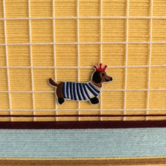 Close-up of Pawsy Puppy yarn wall art showing tight looped wool texture and crisp transitions between mustard, aqua, and white yarn stripes.
