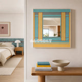 Pear Blossom Tree aqua and golden yellow yarn-framed mirror displayed above a wooden console beside a bright modern bedroom.