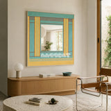 Pear Blossom Tree aqua, golden yellow, and rust yarn-framed mirror displayed above a wood console in a sunlit living room.