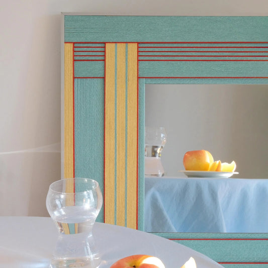 Pear Blossom Tree aqua and yellow fiber mirror displayed above a living room sofa