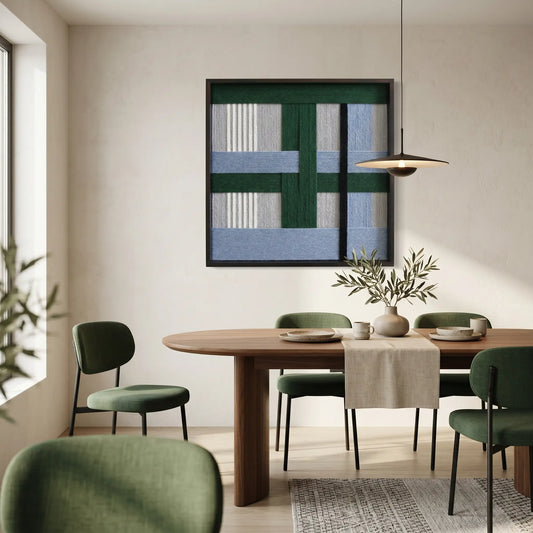Textured fiber wall art styled in a contemporary dining room with dark green chairs and a wooden dining table.