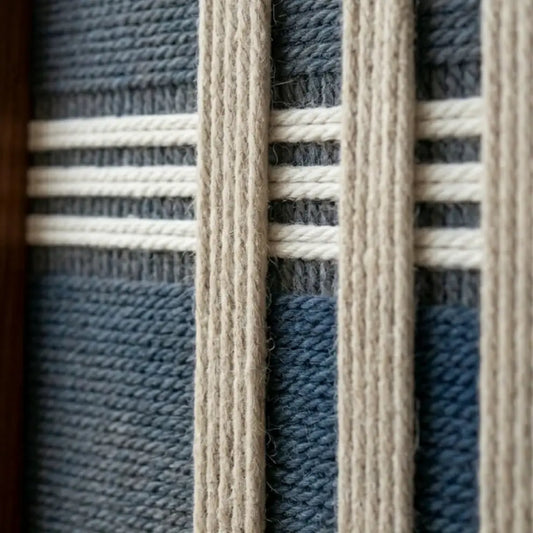 Detailed macro close-up of the Polar Meridian hand-woven textile art highlighting the textured navy blue base and raised white vertical yarn strips.