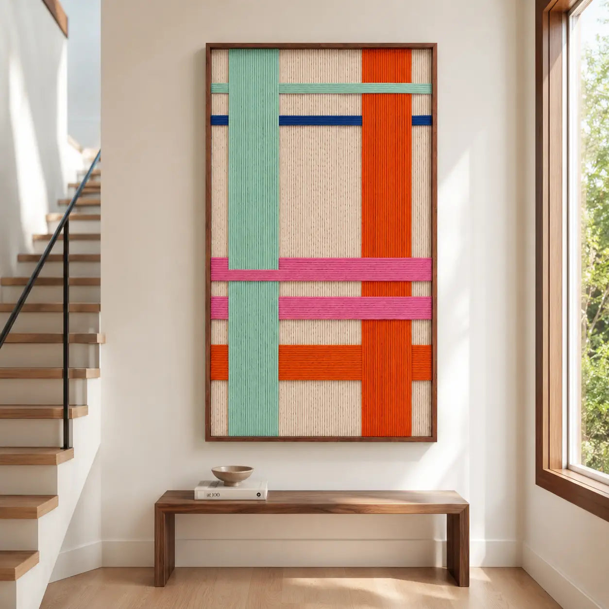 Modern entryway interior styling displaying the large vertical hand-woven wool tapestry hanging above a minimalist wooden bench and warm neutral flooring.
