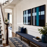 Framed Glacial Stationeries textile wall art with aqua, navy, black, teal, and off-white geometry in a refined room.